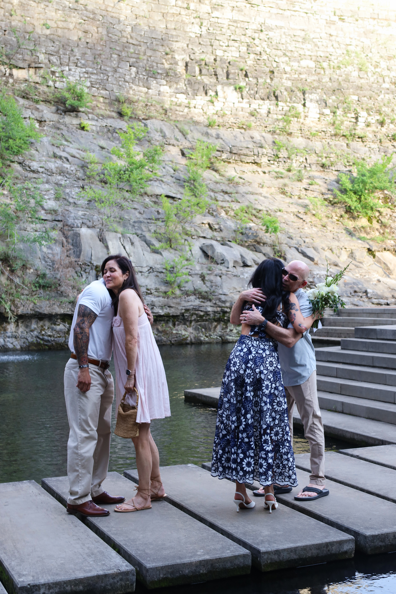 Couple embracing family after the proposal by the water