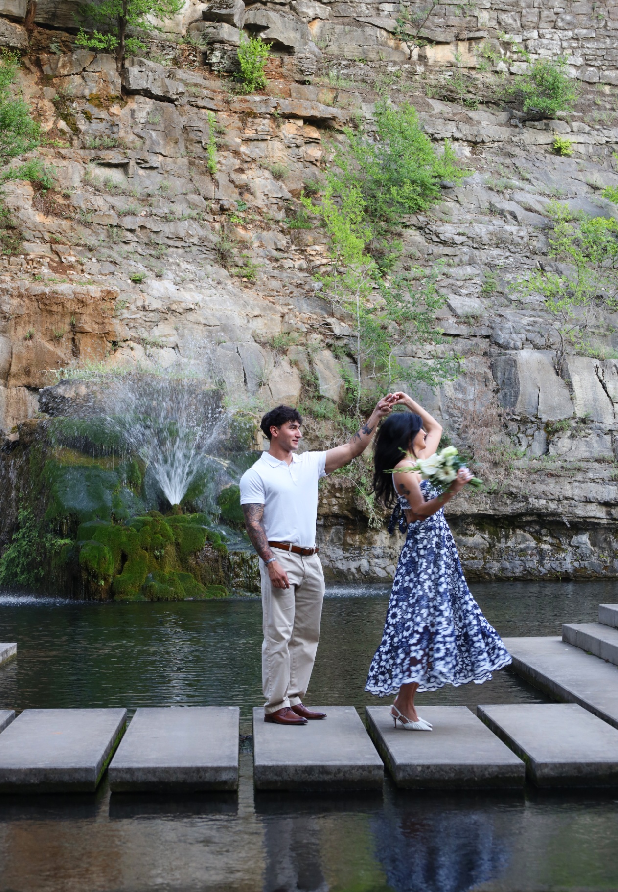Wide portrait of a twirl on stepping stones by the waterfall