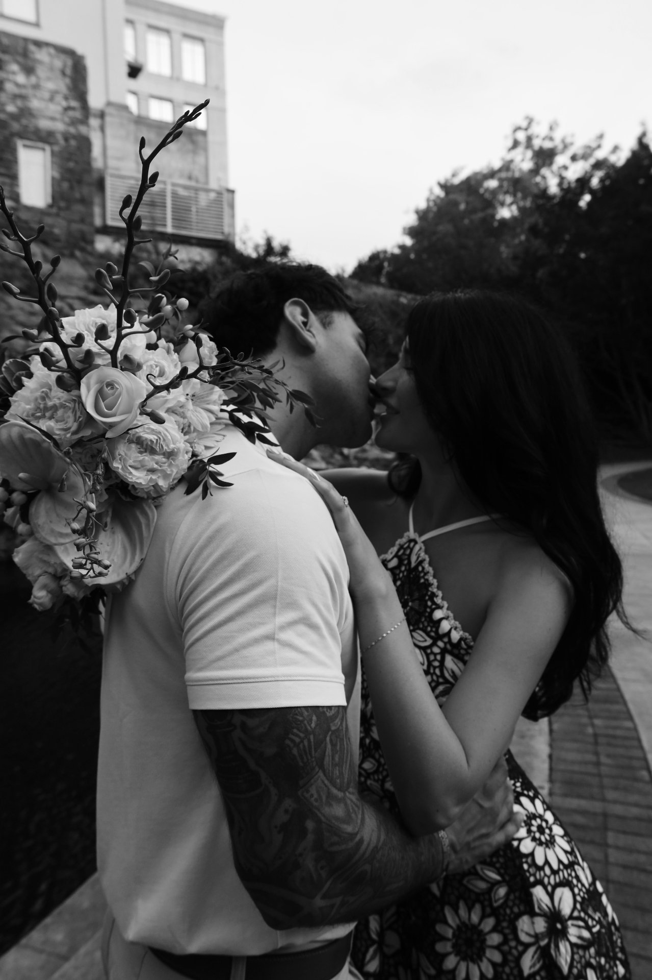 Black and white kiss with white bouquet over the shoulder