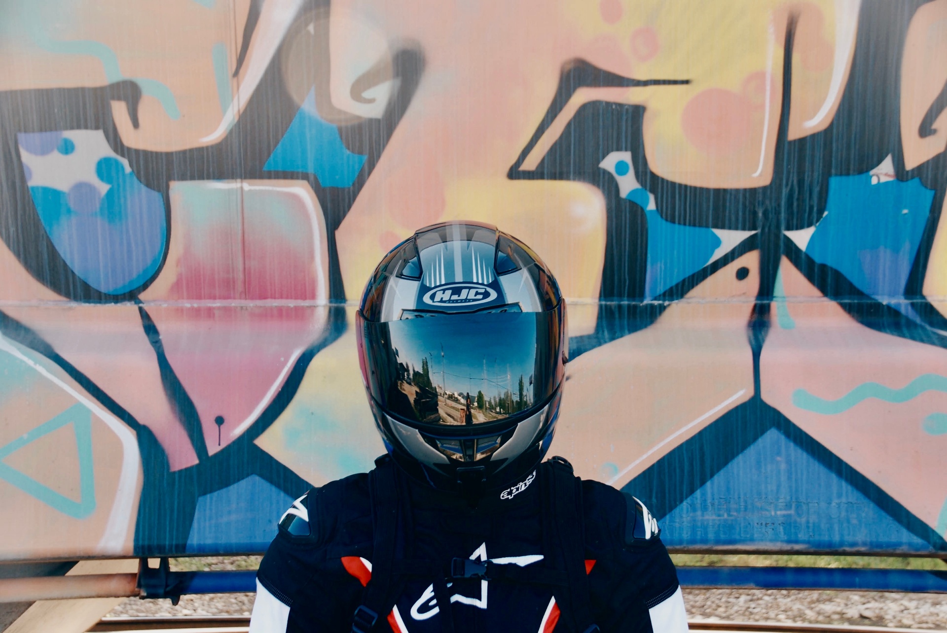 Rider in full gear against graffiti wall