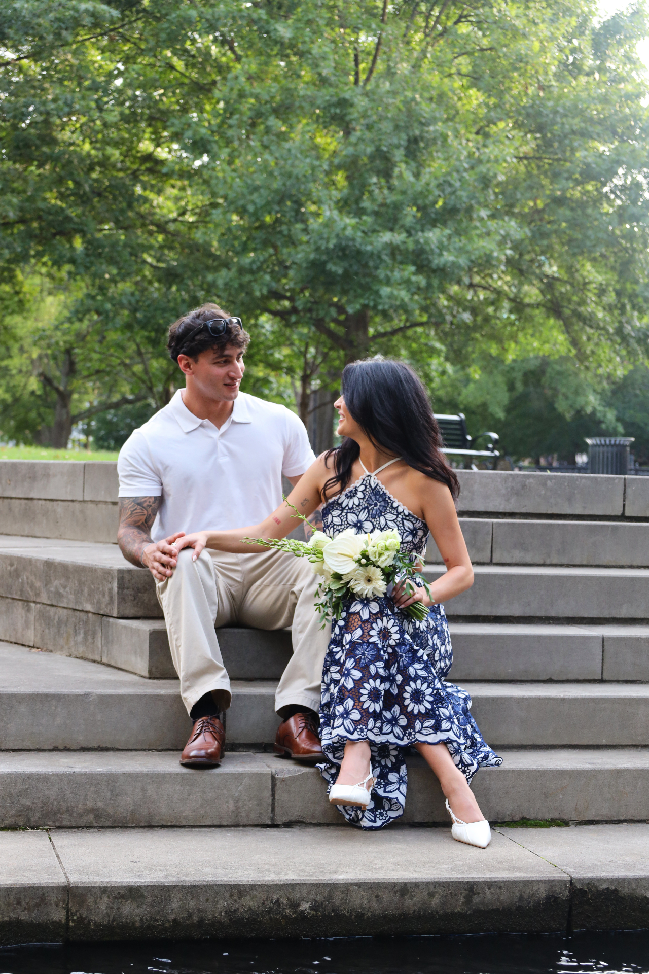 Engaged couple laughing together on stone park steps