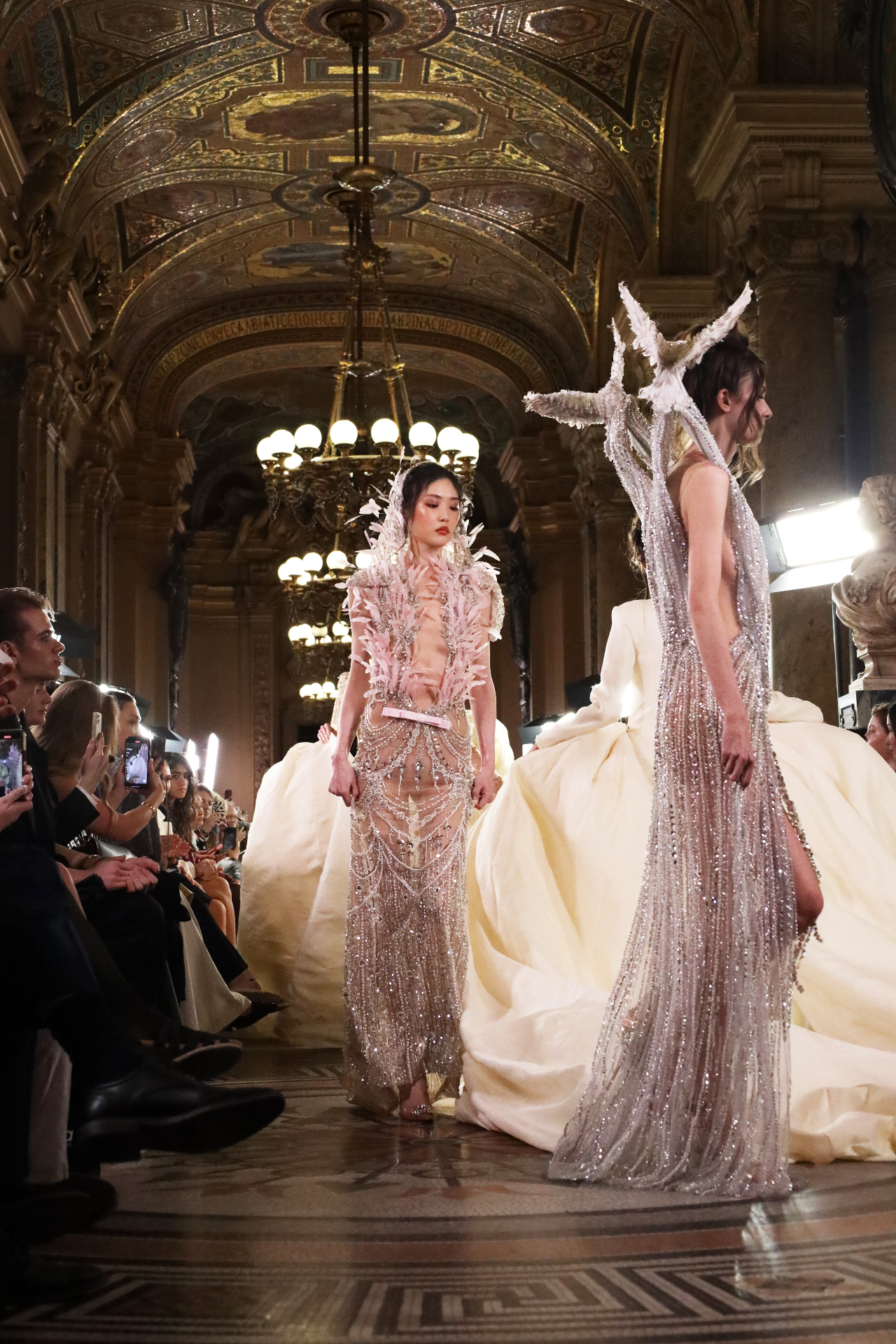 Beaded couture gowns walking through an ornate gilded hall