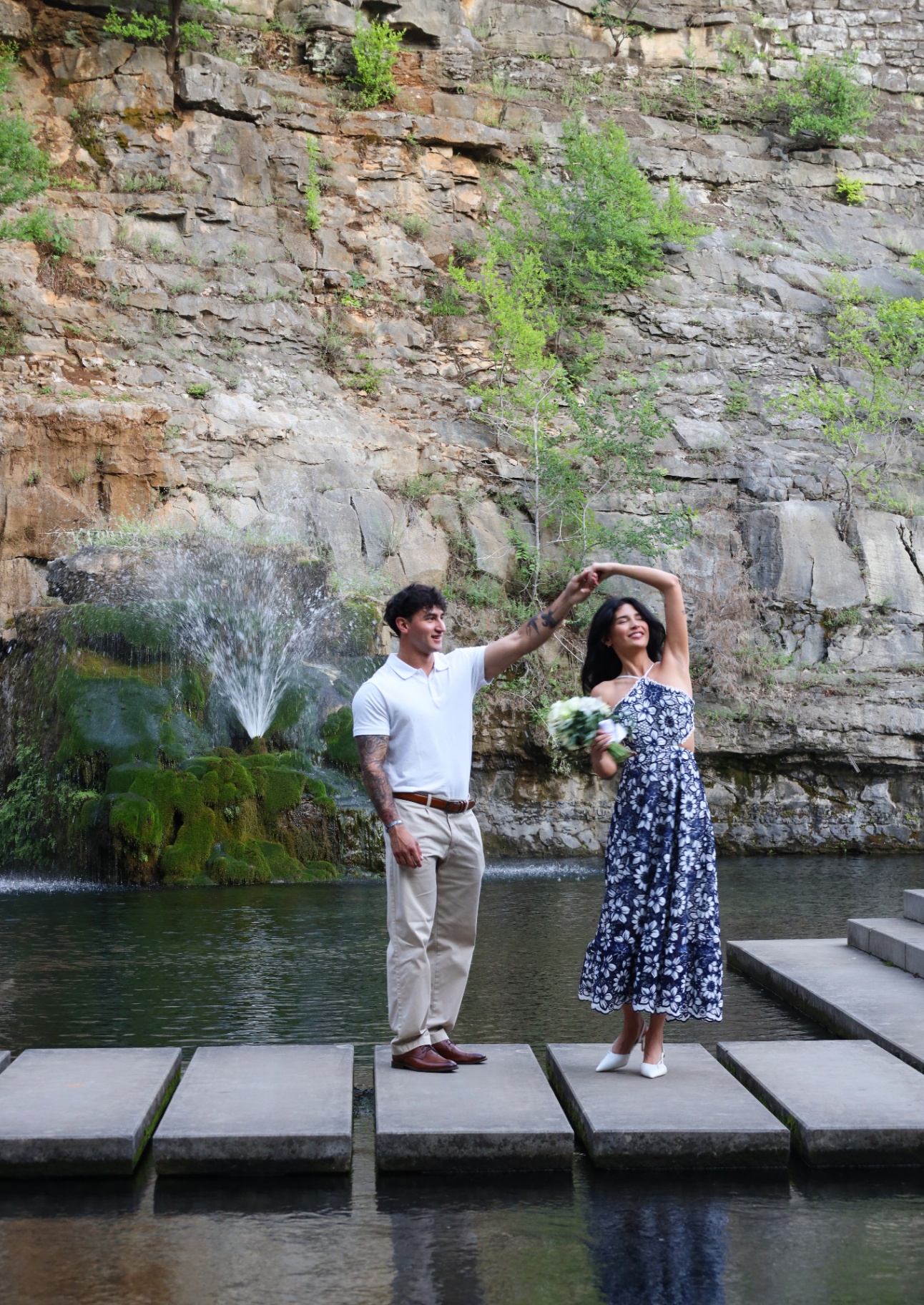 Bouquet-in-hand twirl portrait beside the waterfall