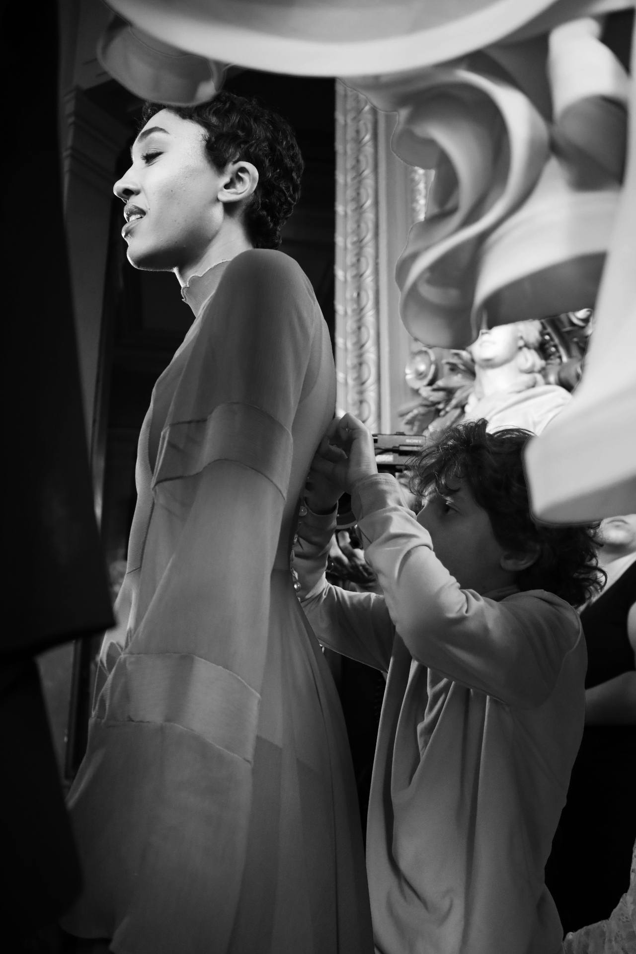 Black and white backstage moment fitting a sheer gown