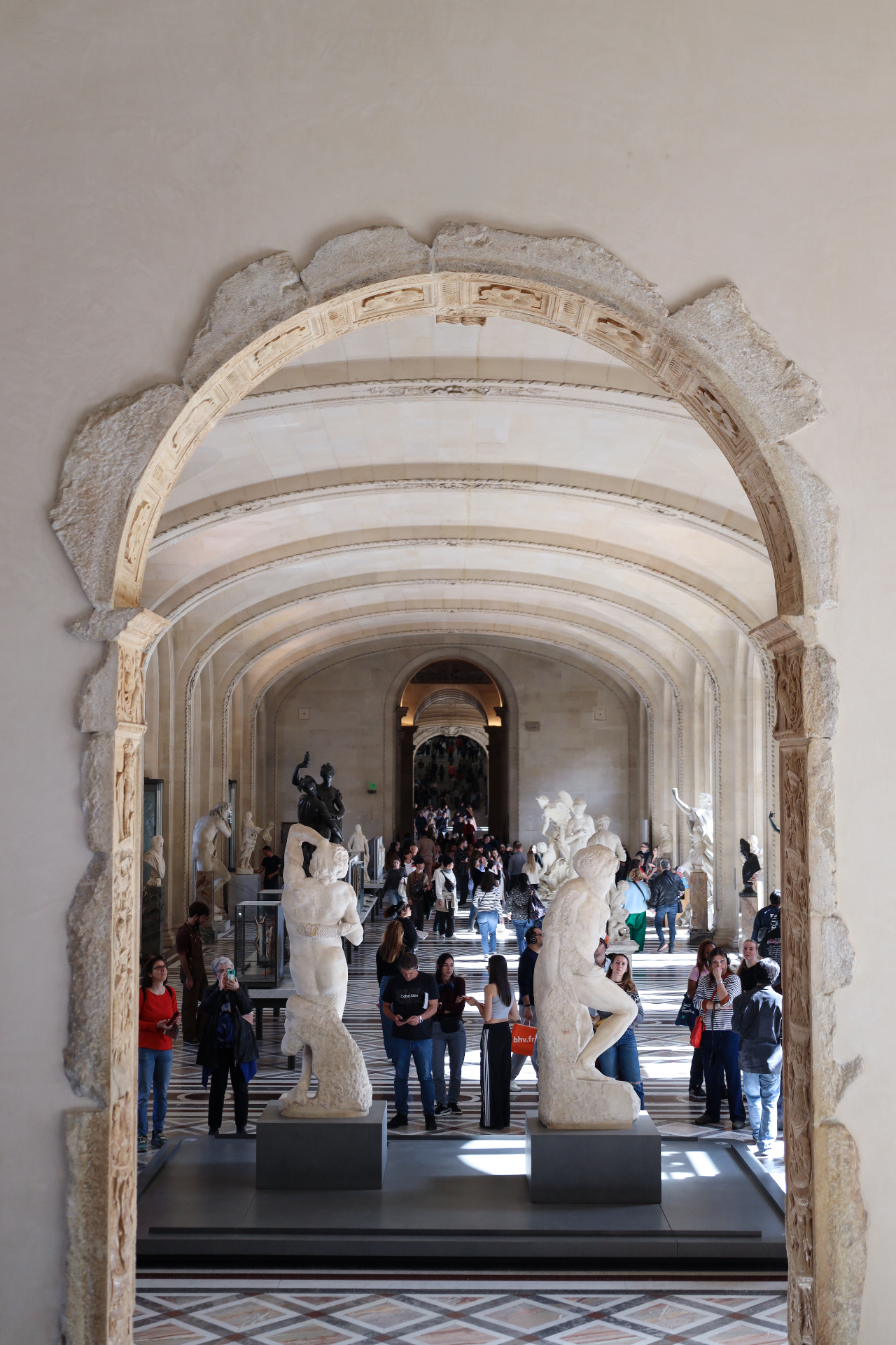 Carved stone archway framing the sculpture hall at the Louvre
