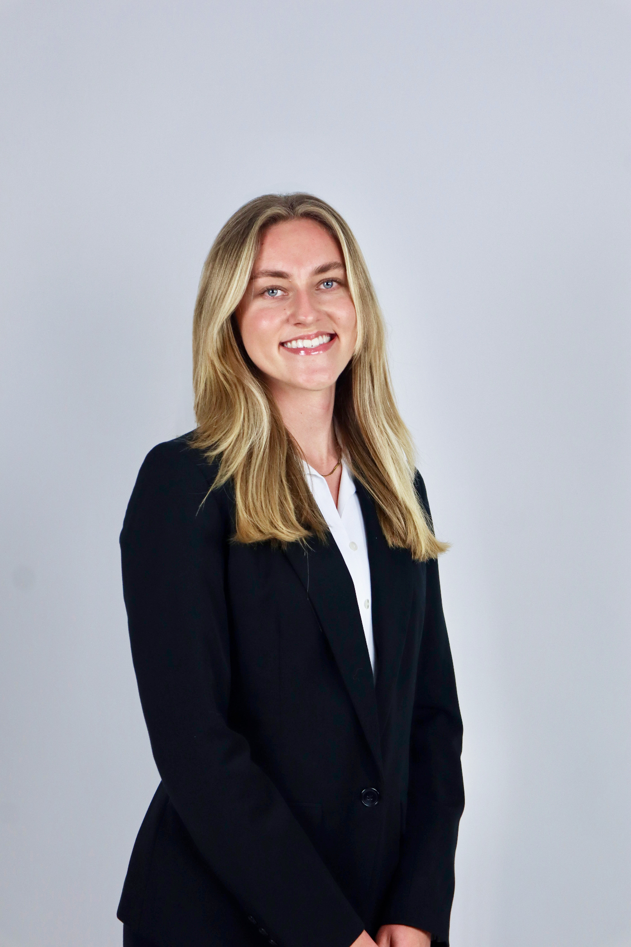 Studio headshot in black blazer and white collared shirt