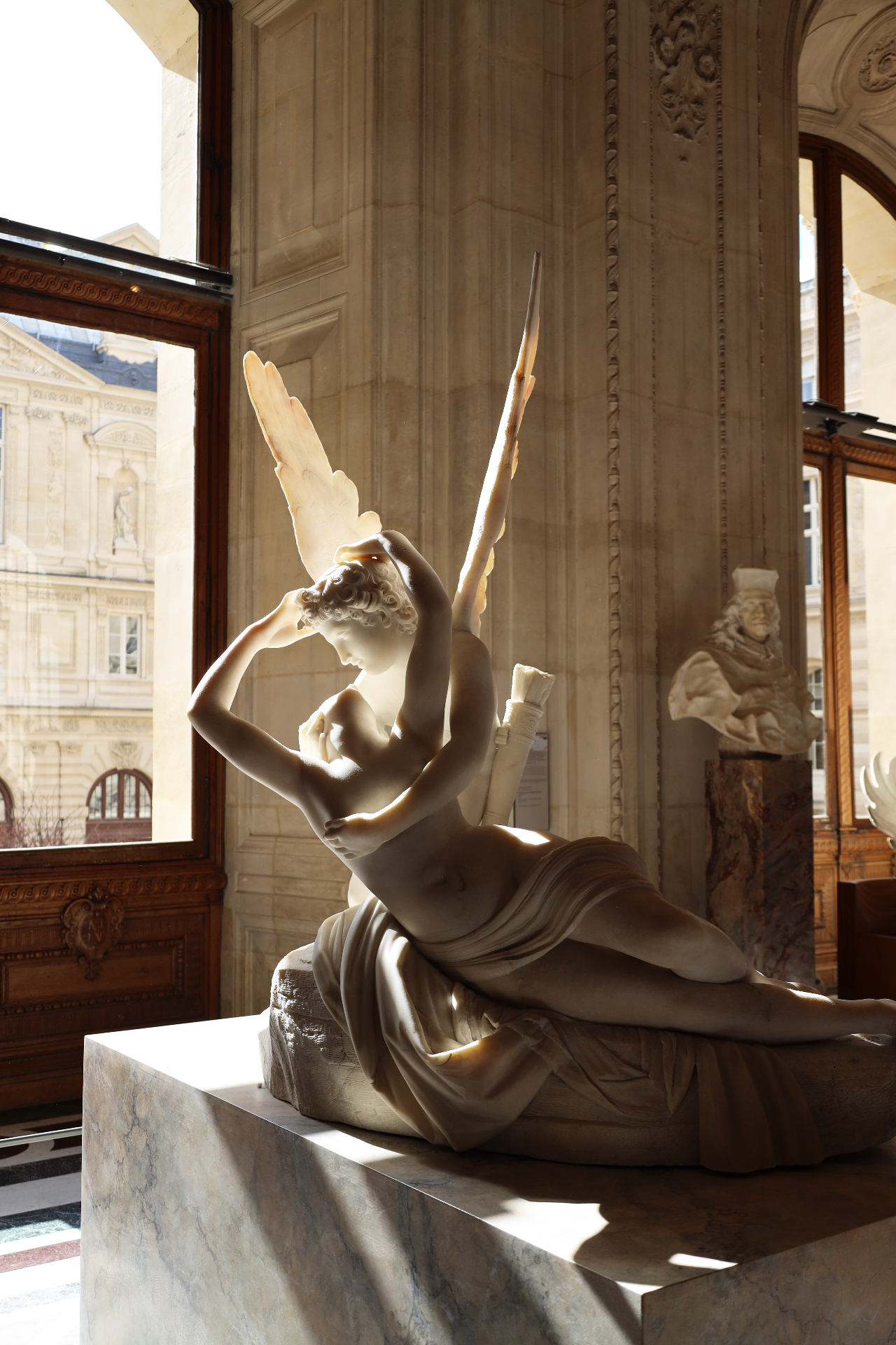 Cupid and Psyche marble sculpture in golden window light at the Louvre