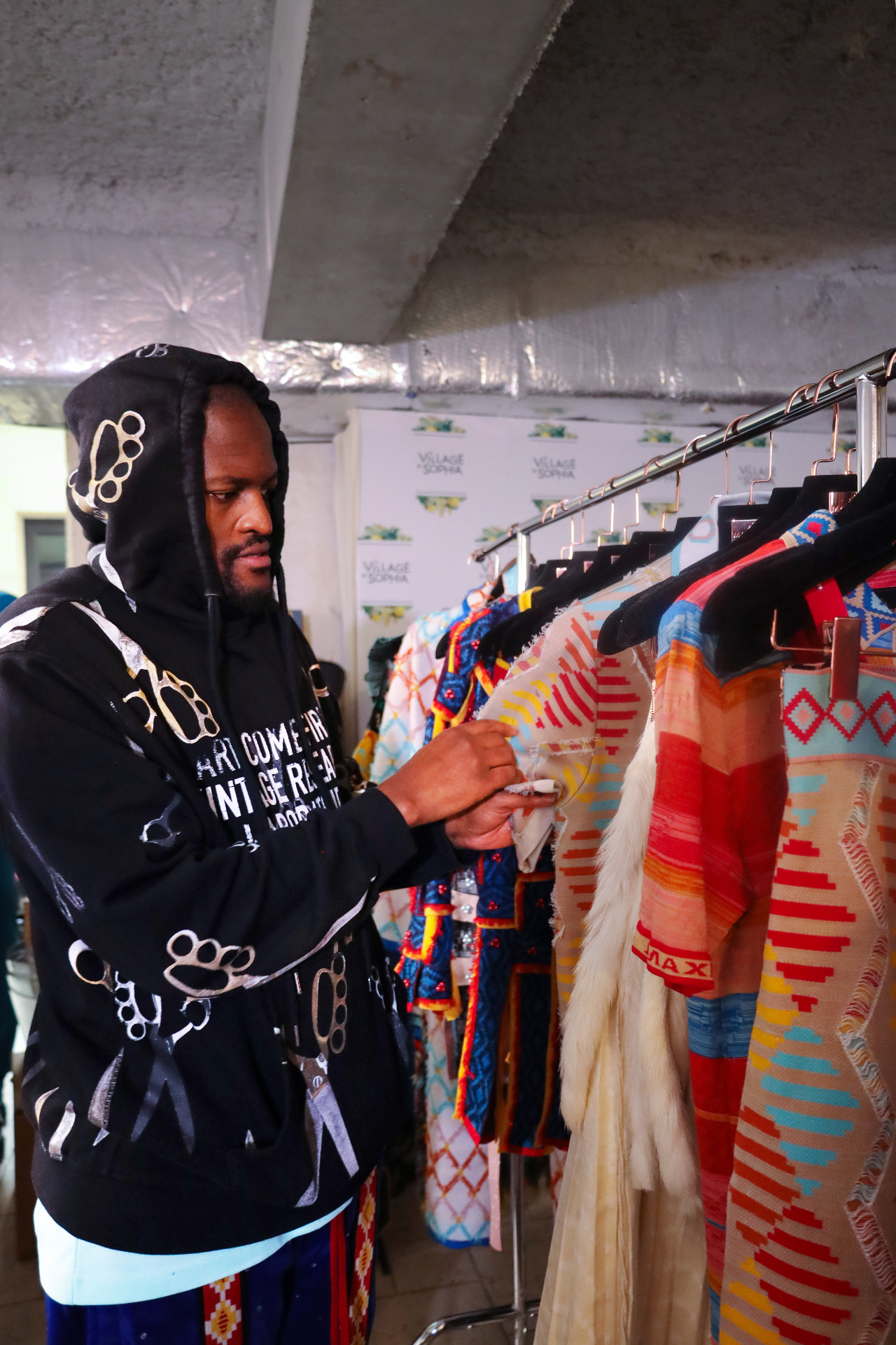 Designer reviewing garments on the rack backstage